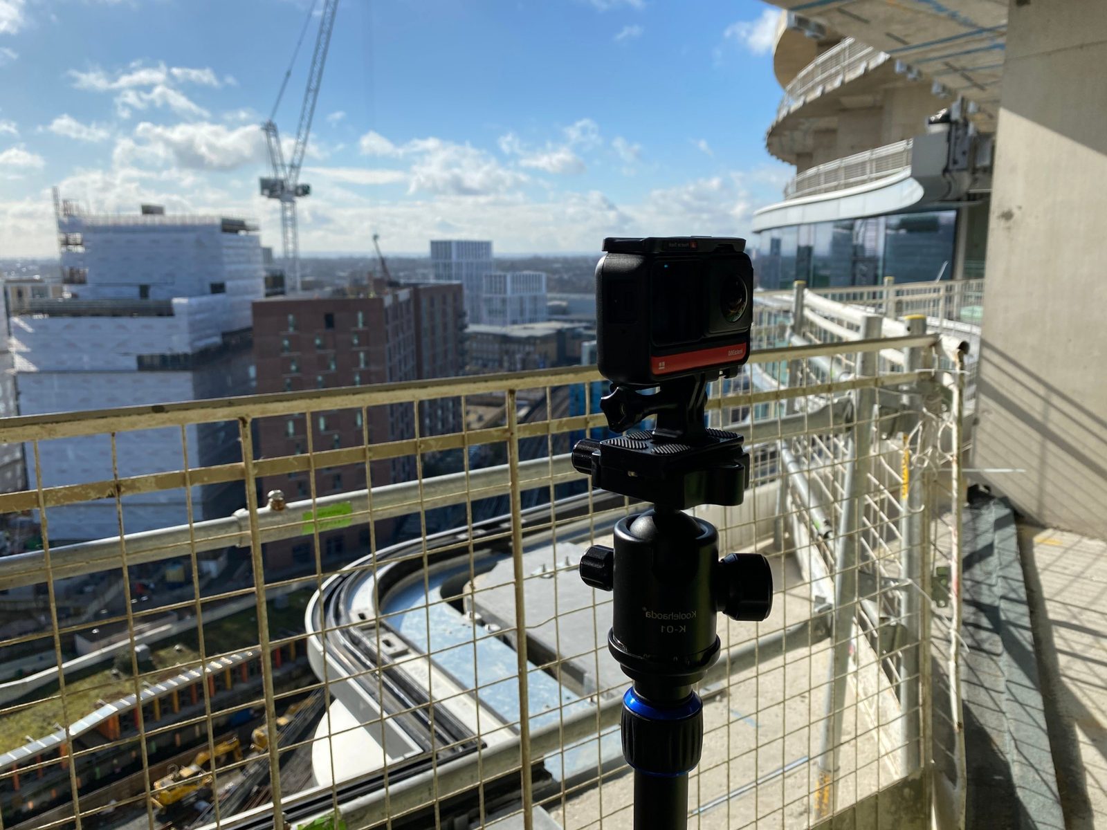 360° camera on a tripod on a high-level balcony overlooking a city construction site