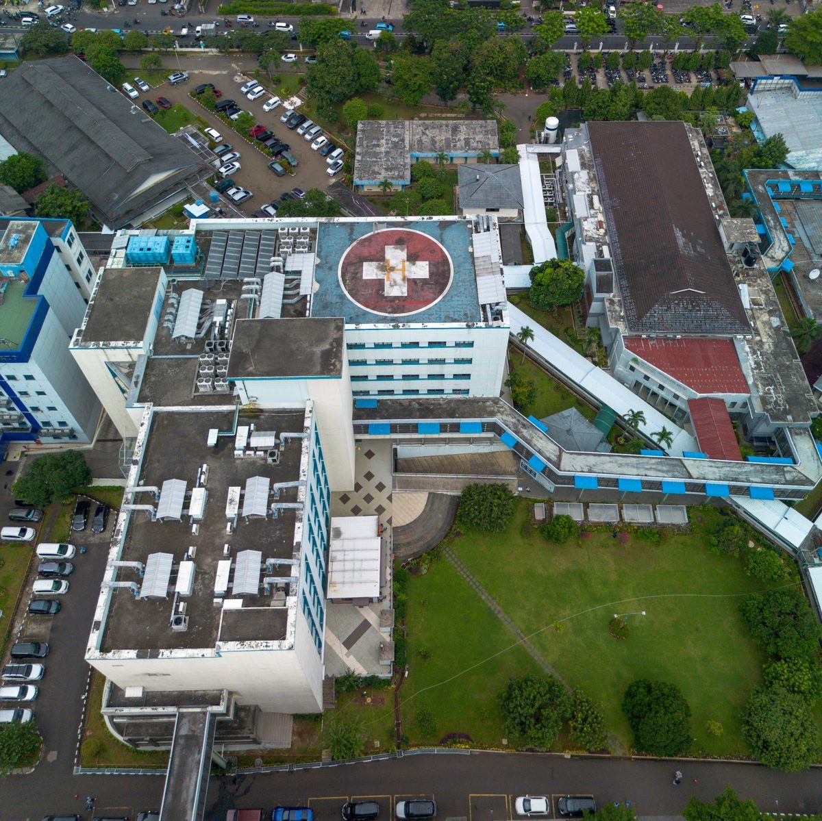 Aerial view of a hospital campus with a rooftop helipad