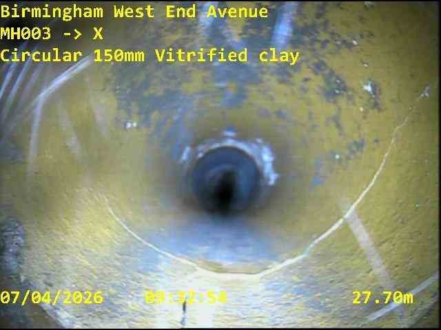 CCTV still from inside a 150mm vitrified clay drainage pipe, with location, run reference and distance overlaid