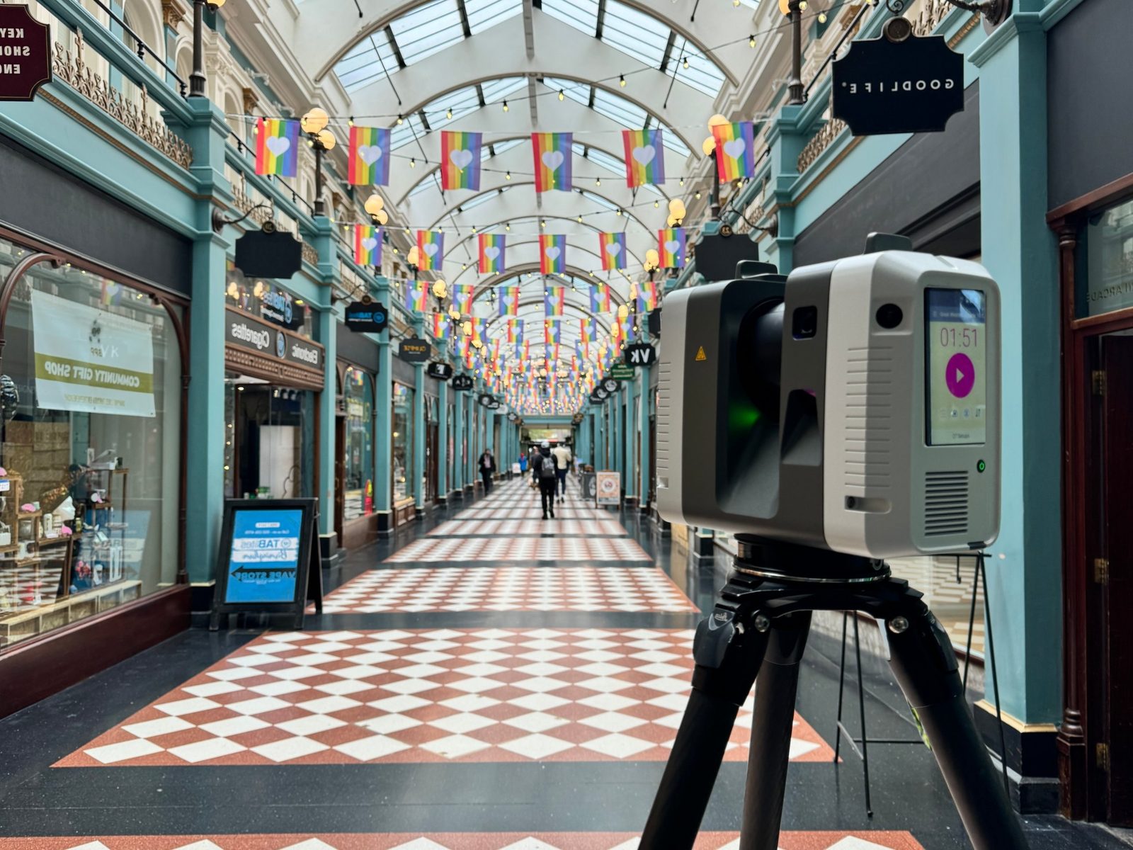 Leica laser scanner on a tripod capturing a Victorian shopping arcade with a glazed barrel-vaulted roof